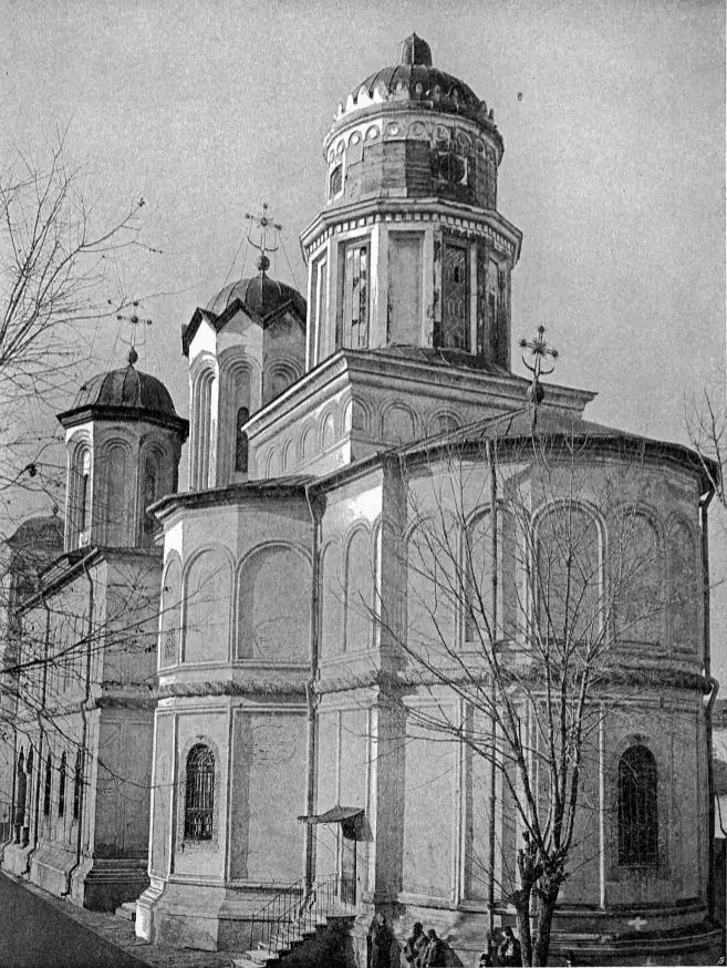 Old black-and-white photograph of a large Orthodox church with domes and an arcaded porch inside a monastery courtyard